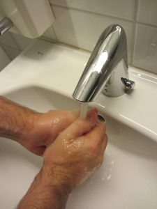 käsiä pestään elektronisen hanan alla